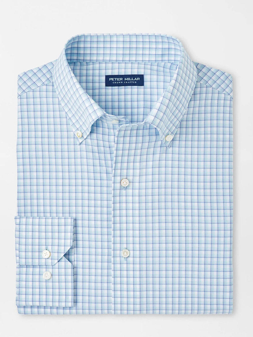 The Peter Millar Parker Performance Poplin Sport Shirt in Blue Spruce is a neatly folded long-sleeve shirt with a label inside the collar, crafted from performance fabric for comfort and UPF 50+ sun protection.