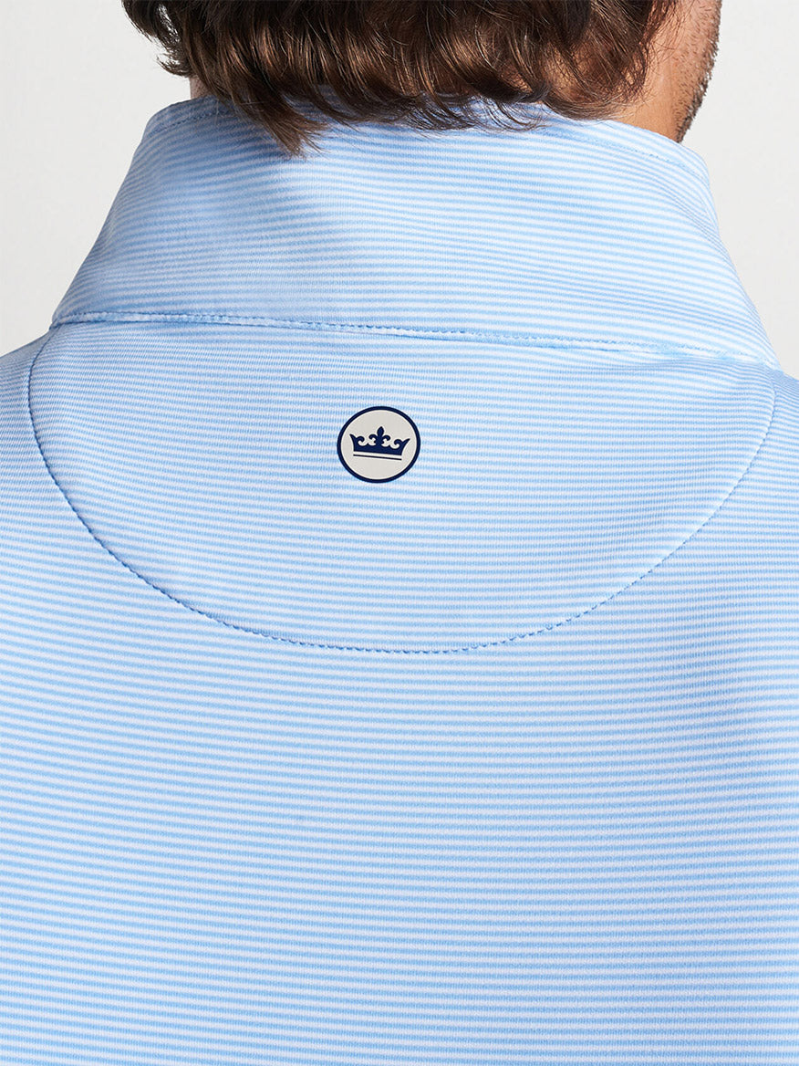 Close-up of the back collar of a Peter Millar Perth Sugar Stripe Performance Quarter-Zip in Cottage Blue/White with a logo.