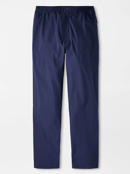 The Peter Millar Rain Walker Pant in Navy, a straight-leg waterproof golf pant with breathable fabric, elastic waistband, and button closure, is displayed laid flat on a white background.