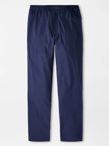The Peter Millar Rain Walker Pant in Navy features a straight-leg design, elastic waistband, and button closure, shown on a white background.
