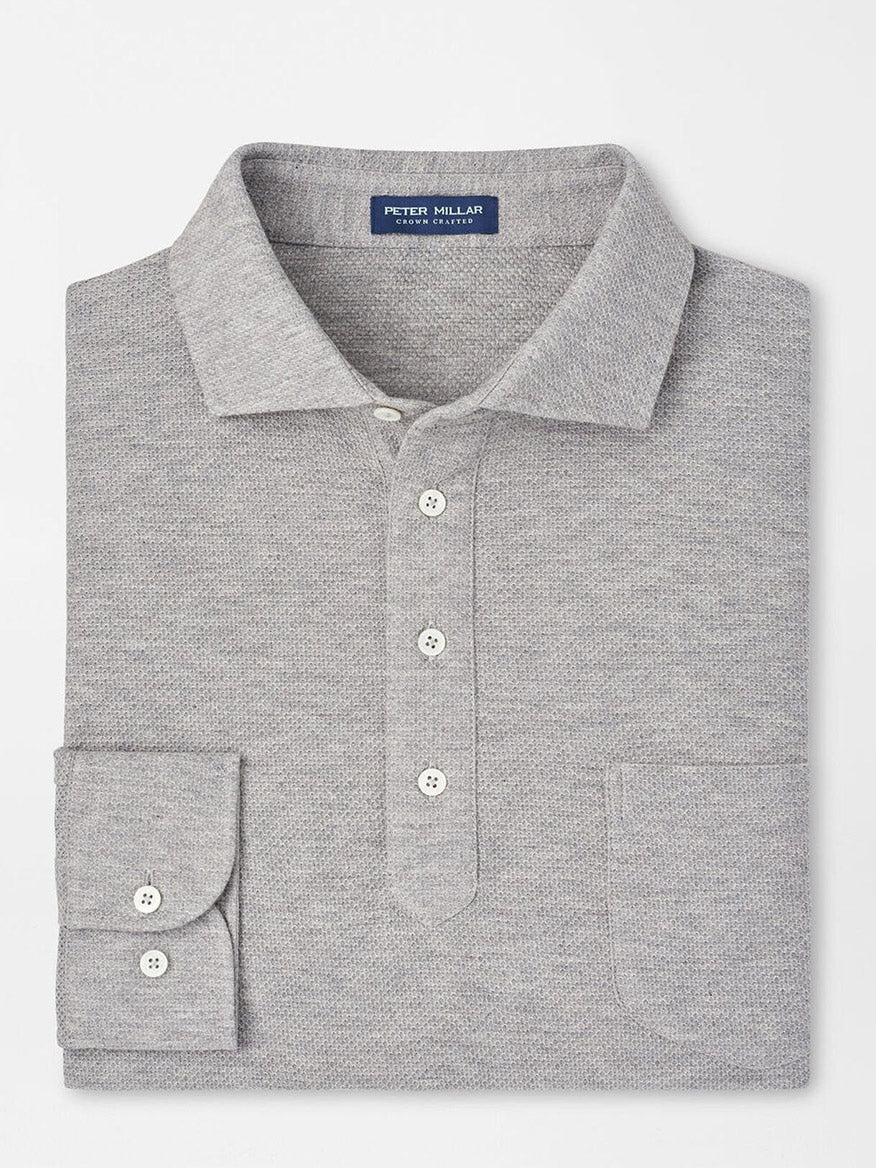 The Peter Millar Ramble Long-Sleeve Cotton Cashmere Polo in Gale Grey, featuring a collar, button placket, and a chest pocket, is showcased folded on a white background.