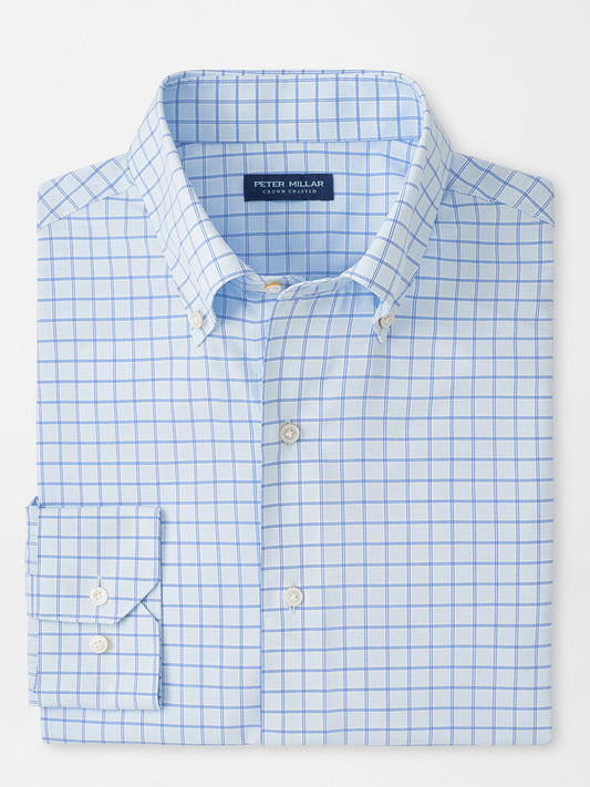 A folded light blue Peter Millar Rampart Performance Poplin Sport Shirt in Blue Brisk features a white and blue checkered pattern and buttoned collar, labeled "Peter Millar.