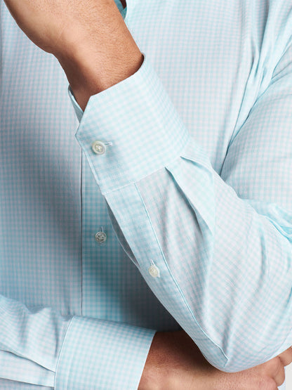 Close-up of a person in a Peter Millar Renato Cotton Sport Shirt in Iced Aqua with a rolled-up sleeve.