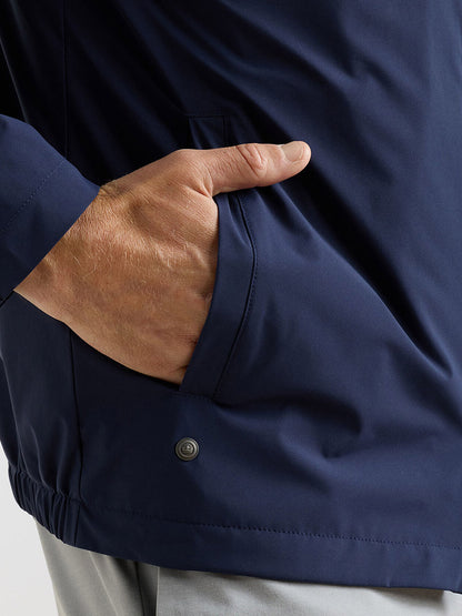 A person wearing the Peter Millar Ryder 3-in-1 Jacket in Navy with their right hand in the jacket pocket.