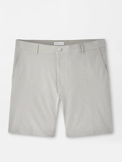 The Peter Millar Shackleford Performance Hybrid Short in British Grey features belt loops, side pockets, a button closure, and is made from four-way stretch, water-resistant fabric. Pictured laid flat on a white background.