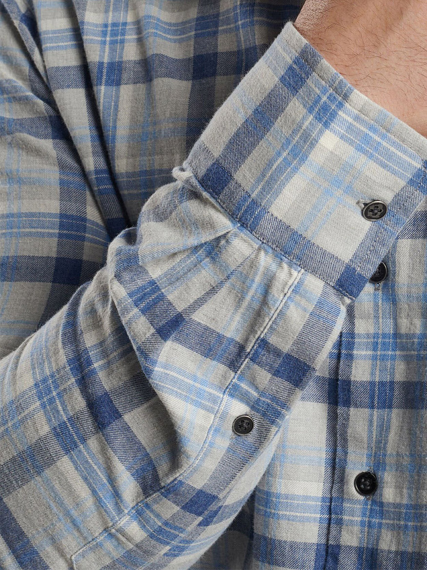 Close-up of a person wearing the Peter Millar Sherbrooke Cotton Sport Shirt in British Grey, featuring a breathable cotton twill fabric in blue and beige plaid, a classic fit with long sleeves, and black buttons.