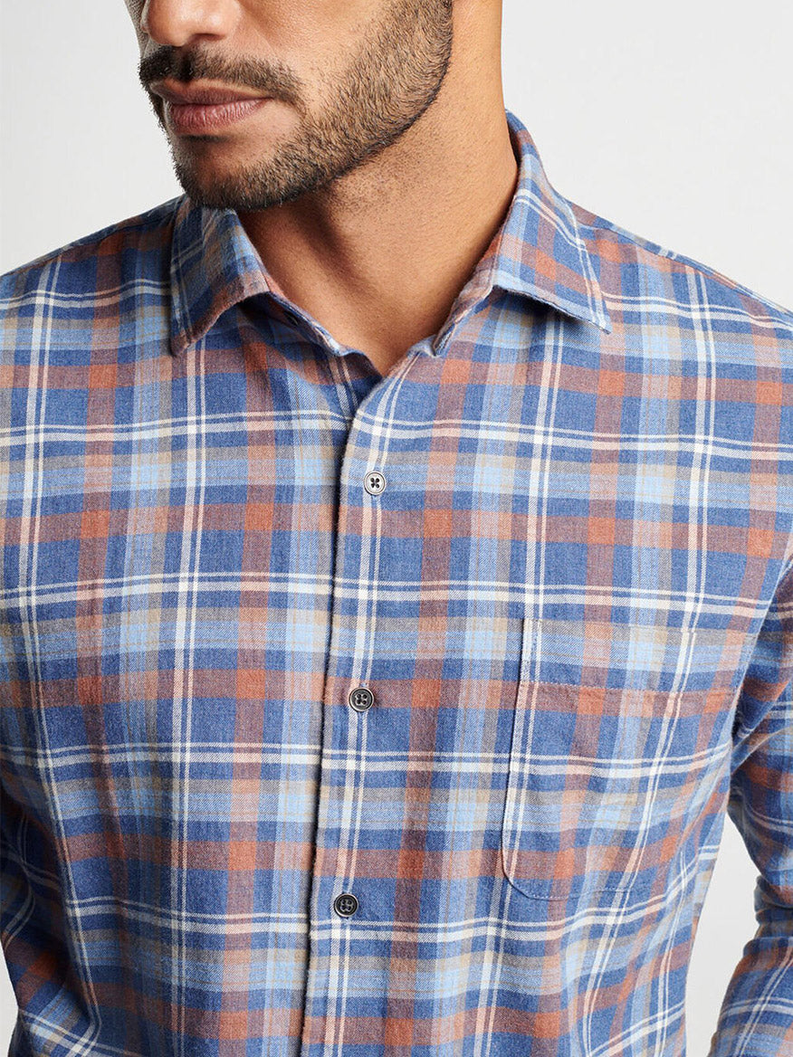 A man wearing the Peter Millar Sherbrooke Cotton Sport Shirt in Ocean Blue, featuring a classic fit and blue and brown plaid pattern, with his face partially visible.