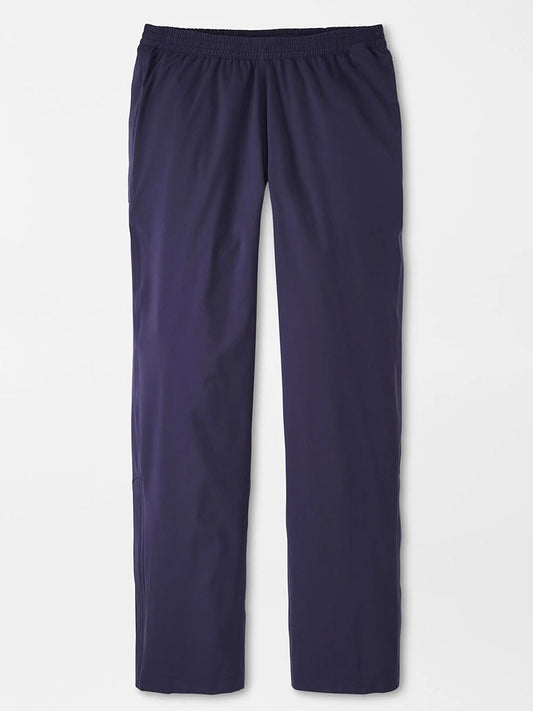 The Peter Millar Shield Pull-On Rain Pant is a dark blue, straight-leg pant with an elastic waistband, made from technical performance fabric for comfort and shown laid flat on a white surface.
