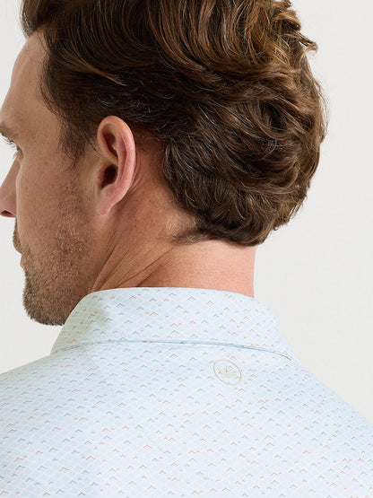 Close-up of the back of a man's head and neck, showing short brown hair and the Peter Millar Soprano Waves Performance Jersey Polo in White with four-way stretch, small printed pattern, and a circular logo below the collar.