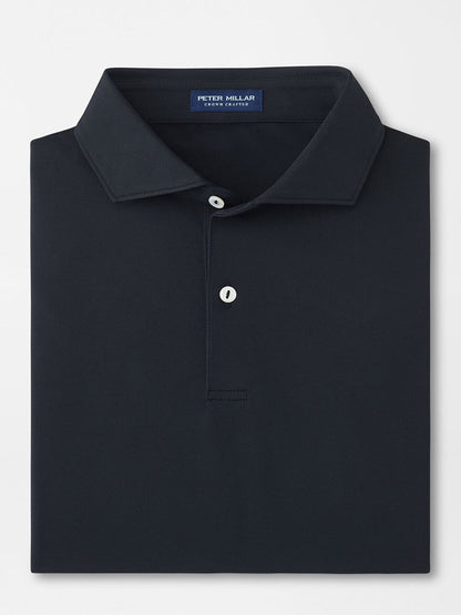 The Peter Millar Soul Performance Mesh Polo in Black is a well-folded, dark-colored shirt with a collar, featuring two mother-of-pearl buttons and an internal neck label.