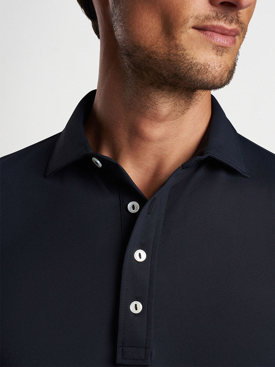 Close-up of a man wearing a Peter Millar Soul Performance Mesh Polo in Black.