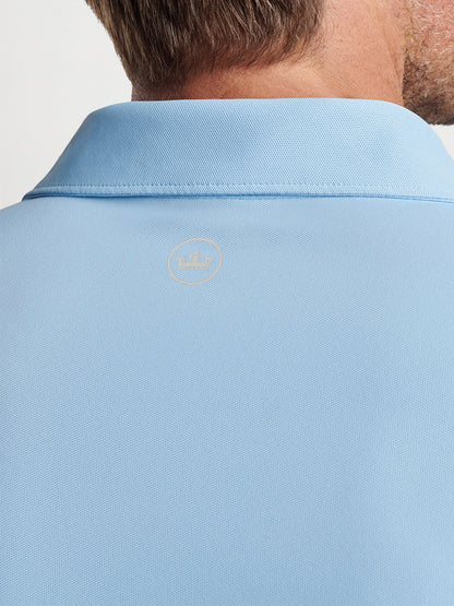 Close-up of the back of a man's Peter Millar Soul Performance Mesh Polo in Blue Frost collar with an embroidered logo.