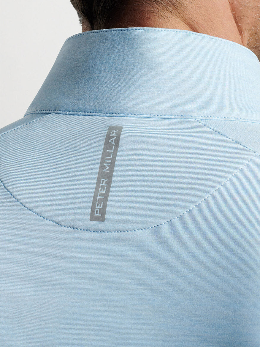 Close-up of a light blue Peter Millar Stealth Performance Quarter-Zip collar with the "peter millar" brand label.