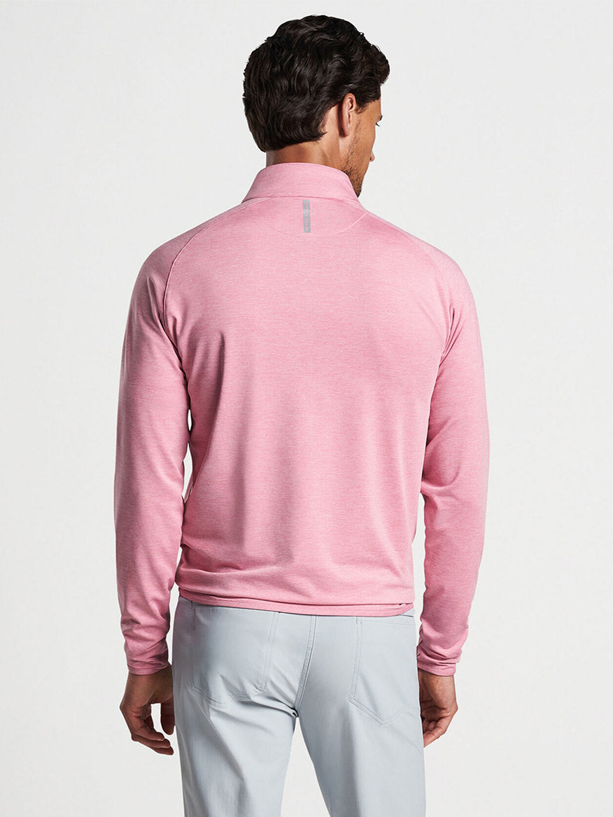 Man wearing a Spring Blossom Peter Millar Stealth Performance Quarter-Zip and grey trousers viewed from the back.