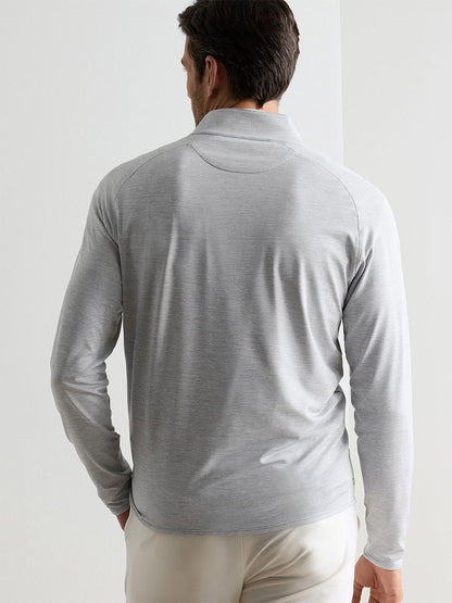 A man faces away, wearing the Peter Millar Stealth Stripe Performance Quarter-Zip in Gale Grey, featuring moisture-wicking fabric, paired with beige pants against a plain light background.
