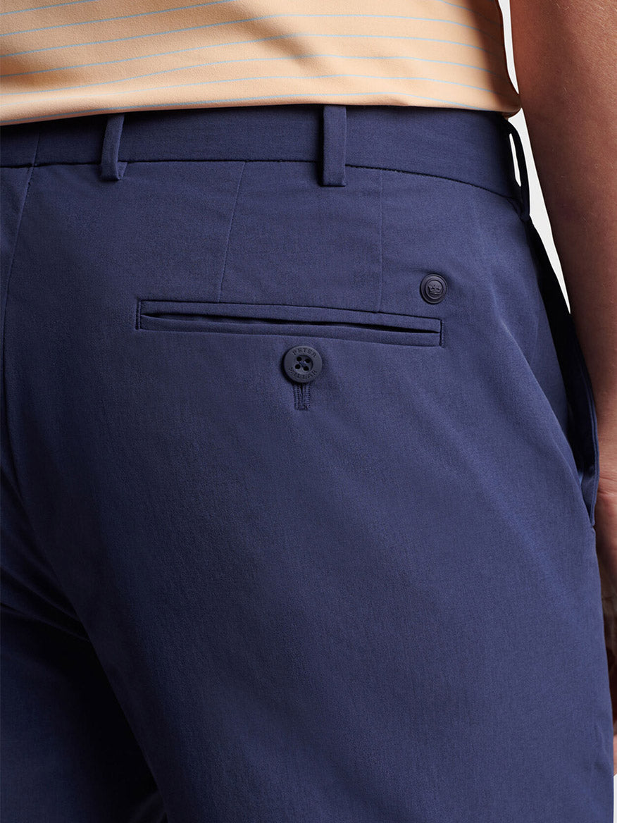 Close-up of a person wearing Peter Millar Surge Performance Short in Navy with a visible pocket and button detail.