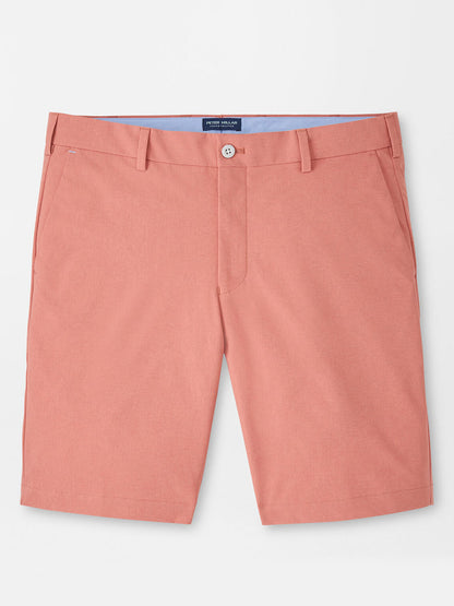 The Peter Millar Surge Performance Short in Faded Scarlet is a pair of four-way stretch tailored shorts with belt loops, button closure, and side pockets, shown laid flat on a white background.