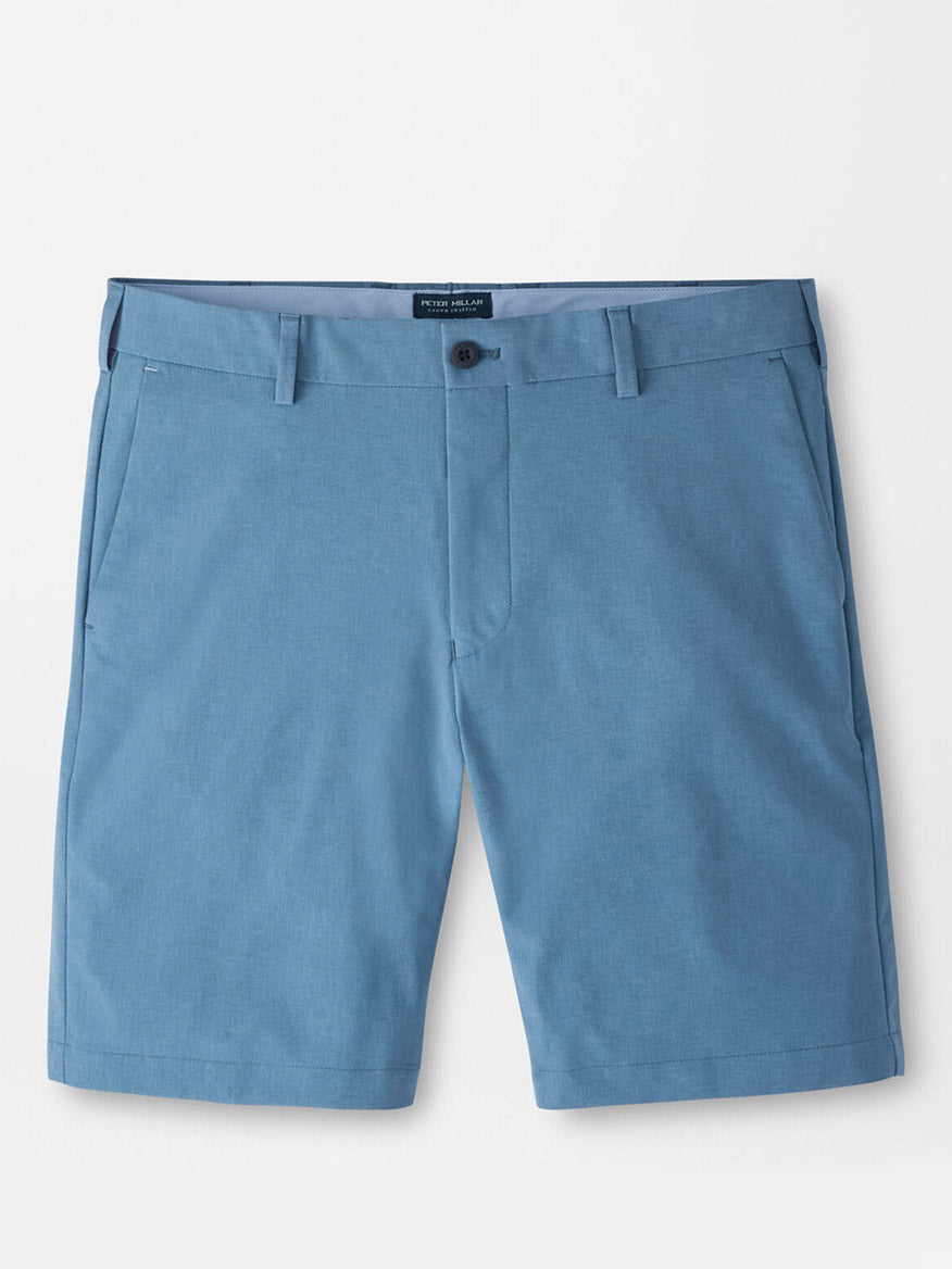The Peter Millar Surge Performance Short in Storm, featuring water-resistant blue fabric, belt loops, button closure, side pockets, and a tailored fit, is displayed flat against a white background.