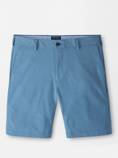 The Peter Millar Surge Performance Short in Storm, featuring water-resistant blue fabric, belt loops, button closure, side pockets, and a tailored fit, is displayed flat against a white background.