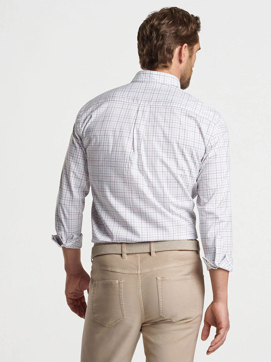 A man with short hair is facing away, wearing a Peter Millar Sydney Crown Lite Cotton-Stretch Sport Shirt in white and beige pants, made from a breathable cotton blend.