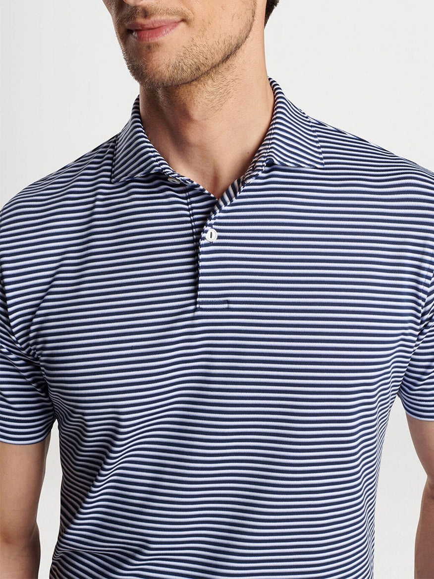 A person wearing the Peter Millar Tempo Performance Mesh Polo in navy, featuring vintage-inspired collars, stands against a neutral background.