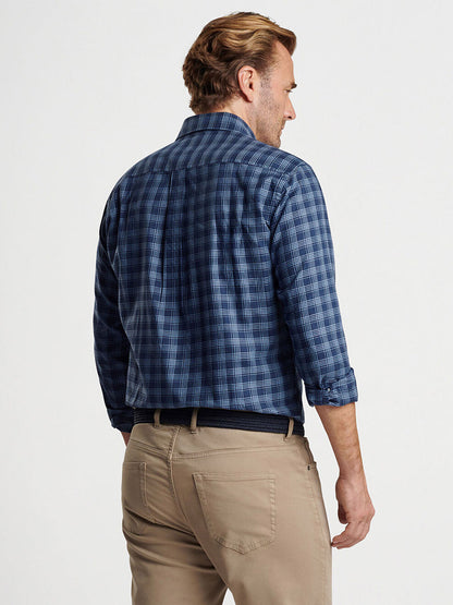 A man with light brown hair is wearing a Peter Millar Thompson Summer Soft Cotton Sport Shirt in Galaxy and beige pants, facing away from the camera.