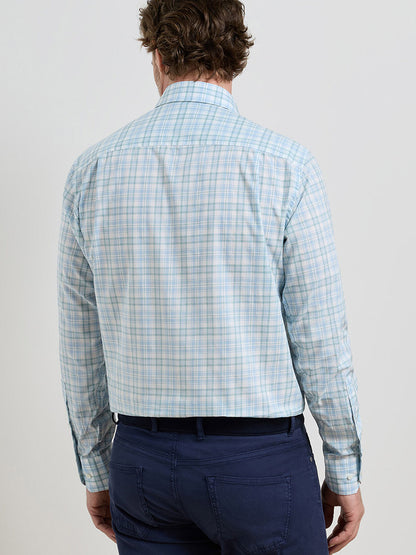 A man is shown from the back against a plain background wearing the Peter Millar Tropea Italian Poplin Sport Shirt in Light Willow and navy blue pants.