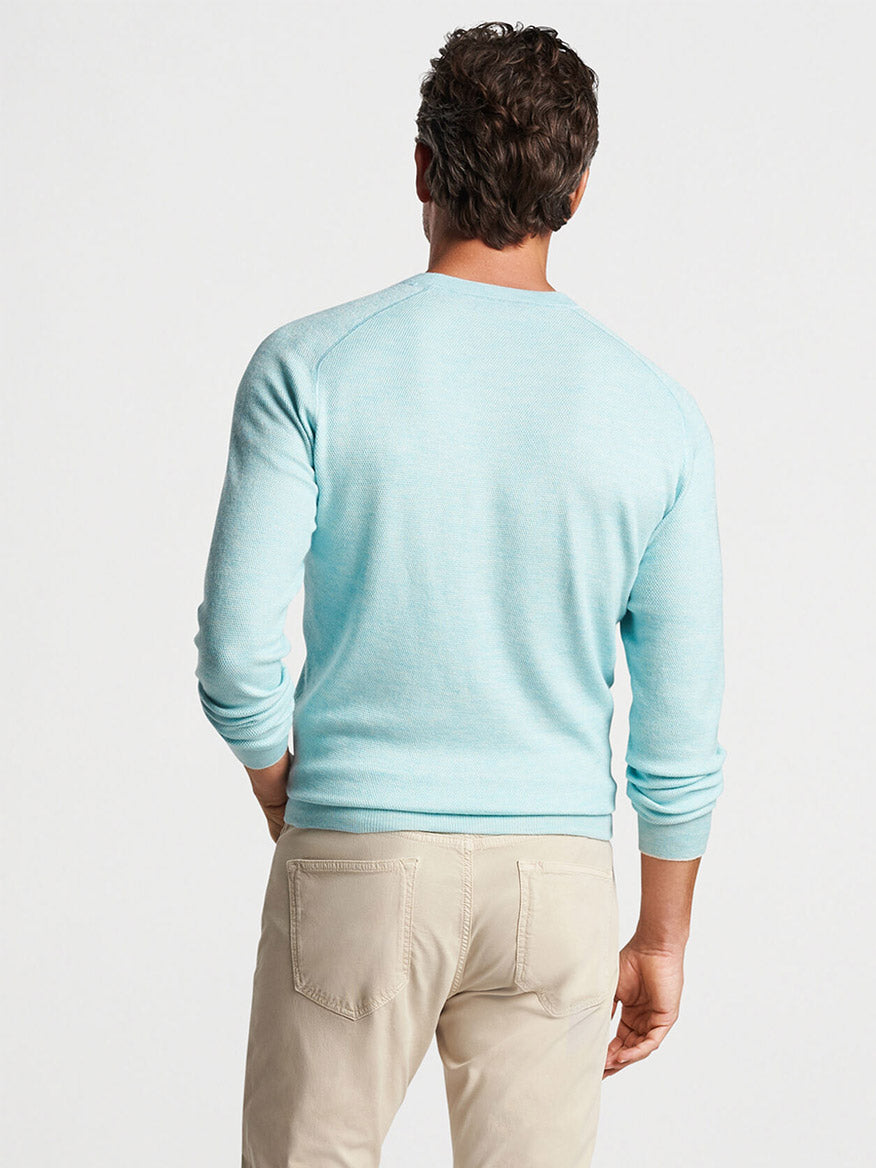 The back of a man wearing a Peter Millar Voyager Cashmere-Silk Saddle Shoulder Crew in Iced Aqua.