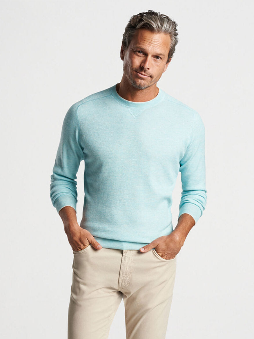 A man in a Peter Millar Voyager Cashmere-Silk Saddle Shoulder Crew in Iced Aqua sweater.
