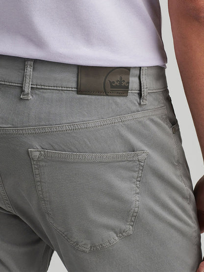 A person wearing Peter Millar Wayfare Five-Pocket Pant in Classic Grey, highlighting the five-pocket design with a visible back pocket and a leather patch featuring the crown logo near the waistband.