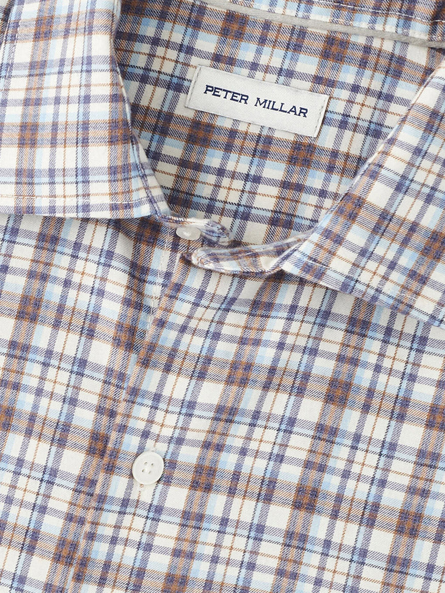 A close-up of the Peter Millar Waynesville Performance Flannel Sport Shirt in Winter Ivory, showcasing a blue, brown, and white plaid pattern made from soft performance fibers—your ideal go-to for fall.