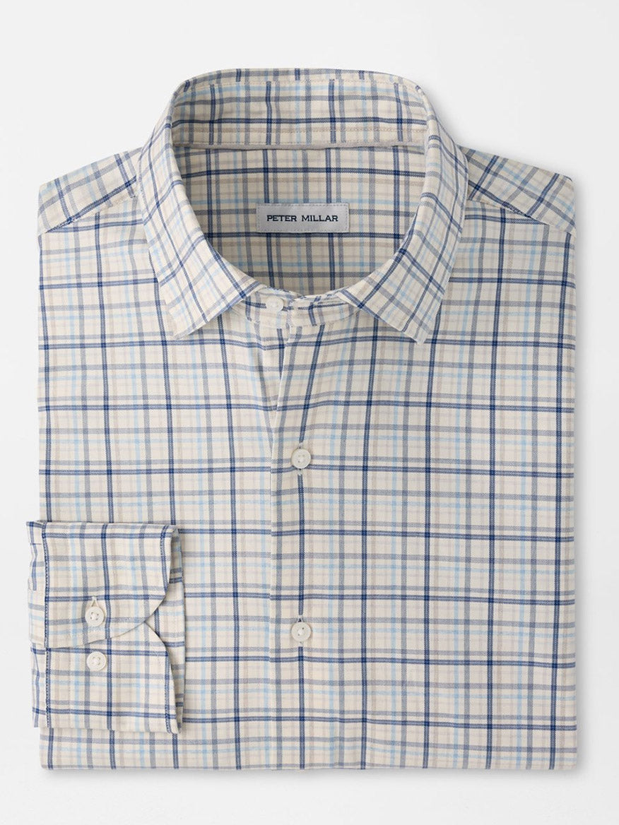 A folded Peter Millar Wyatt Crown Soft Twill Sport Shirt in Multi, featuring a blue and beige plaid pattern with long sleeves and crafted from easy-care stretch performance fabric. The label inside the collar reads “Peter Millar.”.