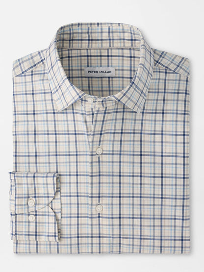 A folded Peter Millar Wyatt Crown Soft Twill Sport Shirt in Multi, featuring a blue and beige plaid pattern with long sleeves and crafted from easy-care stretch performance fabric. The label inside the collar reads “Peter Millar.”.