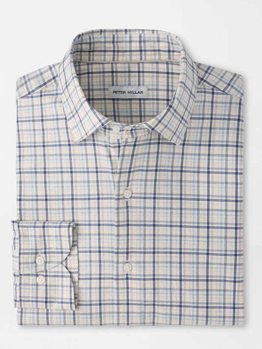 A folded Peter Millar Wyatt Crown Soft Twill Sport Shirt in Multi, featuring a blue and beige plaid pattern with long sleeves and crafted from easy-care stretch performance fabric. The label inside the collar reads “Peter Millar.”.