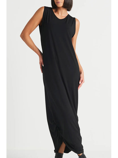 A person wearing the Planet by Lauren G Matte Jersey Ruched Tank Dress in Black stands against a plain white background. The sleeveless black maxi dress, which reaches their ankles, features subtle ruching detail and appears loose-fitting and elegantly understated.