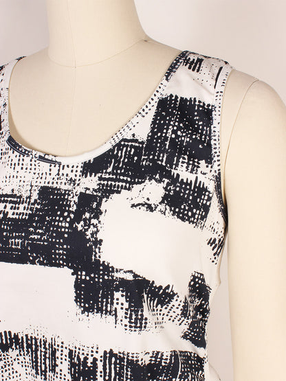 Close-up of a sleeveless white Porto Casbah Dress in Naples Spumante with a black abstract pattern on a mannequin, showcasing its modern design and lightweight woven fabric.