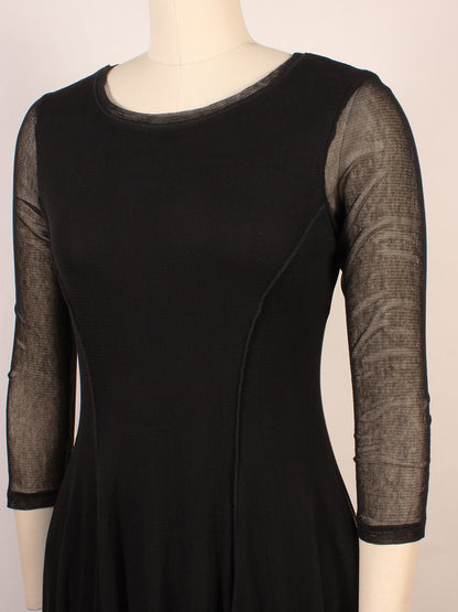 A mannequin dressed in the Porto Pendulum Dress in Black, featuring a fit-and-flare silhouette, sheer three-quarter sleeves, and a round neckline.
