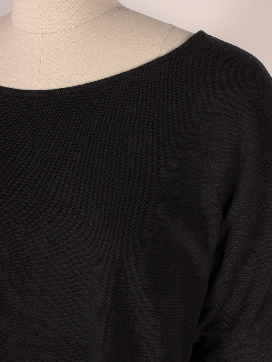 Close-up of a Porto Tara Mesh Oversize Knit Top in Black on a beige mannequin, made in Italy, showing the neckline and shoulder area.