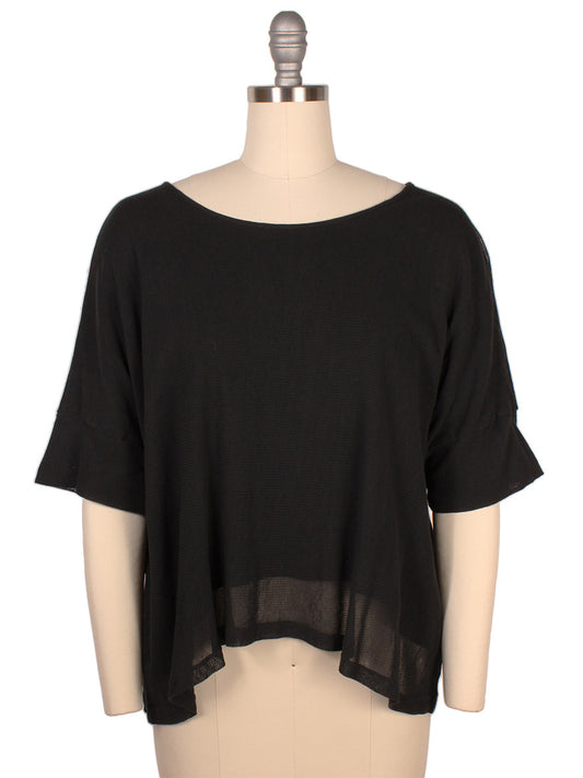 Mannequin displaying a Porto Tara Mesh Oversize Knit Top in Black with short sleeves, a slightly sheer lower hem, and crafted from cotton mesh, made in Italy.