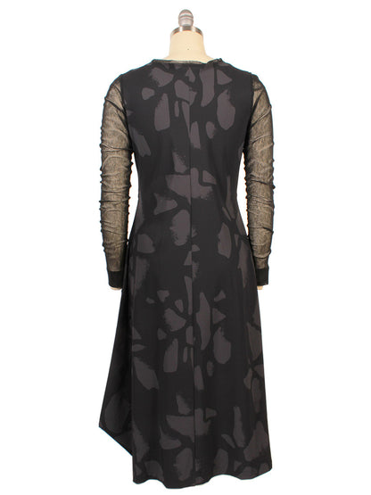 The Porto Venetian Dress in Smoke Palermo features mesh long sleeves and an abstract dark gray pattern. Displayed on a dress form from the back. Made in Italy.