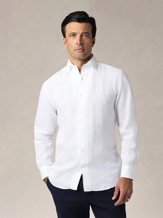 A man stands facing forward wearing a Robert Talbott Morgan Linen Shirt in White and dark pants against a plain light background.