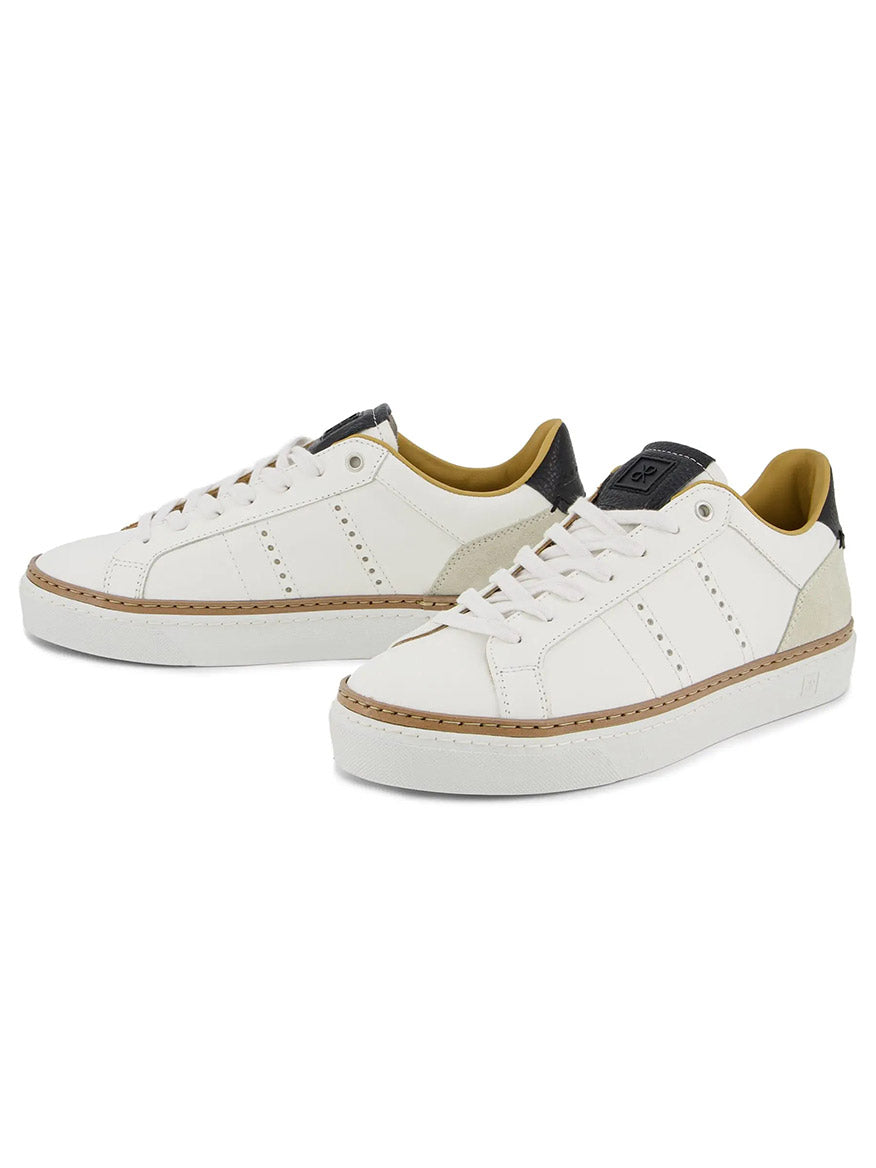 The Rubirosa AVA Sneakers in White are low-tops with beige and black accents, perforated sides, and thick white soles, offering a classic retro tennis shoe style.