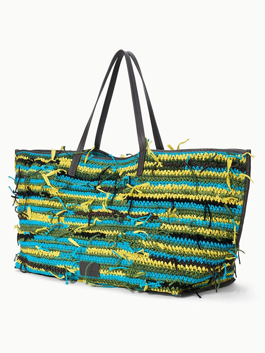 The STAUD Christos Large Tote in Happy Sack is a spacious handcrafted bag with black handles, showcasing a yellow, blue, and black textured pattern and loose fringe-like threads for added style.