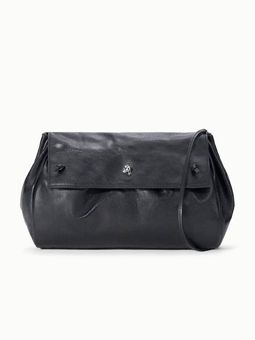 STAUD Cy Convertible Bag in black leather with a fold-over design, a slim strap, and a silver-toned metal closure.