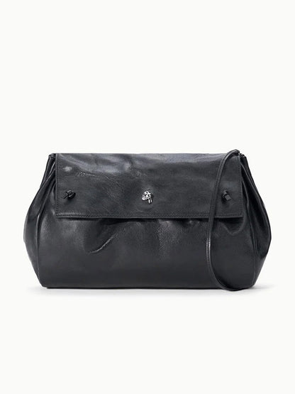 STAUD Cy Convertible Bag in black leather with a fold-over design, a slim strap, and a silver-toned metal closure.