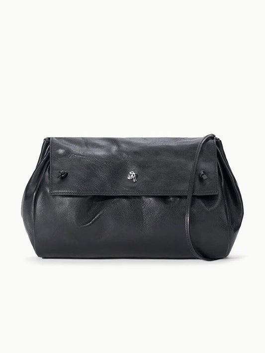 STAUD Cy Convertible Bag in black leather with a fold-over design, a slim strap, and a silver-toned metal closure.