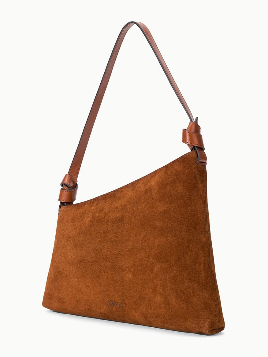 STAUD Dani Shoulder Bag in Tabac, crafted from brown suede with a single adjustable leather strap and featuring an elegant asymmetrical silhouette, photographed against a plain white background.