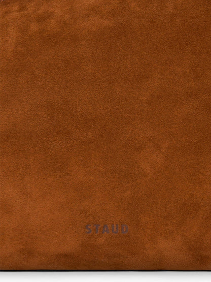 Close-up of brown suede material with the word “STAUD” subtly embossed near the bottom center, highlighting the refined texture of the STAUD Dani Shoulder Bag in Tabac.