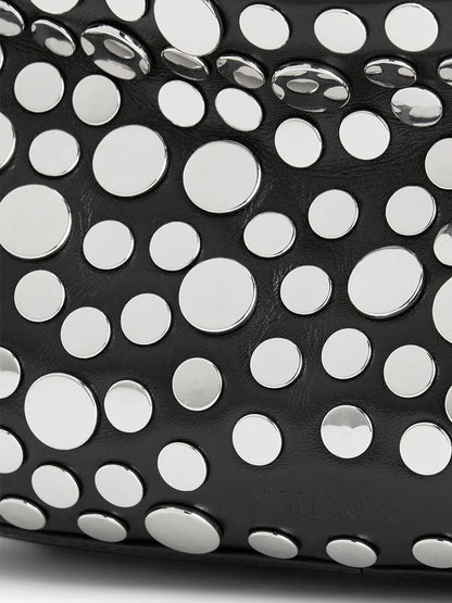 Close-up of the STAUD Demy Shoulder Bag in Rivets, showing black nappa leather adorned with scattered round, flat silver studs in various sizes.