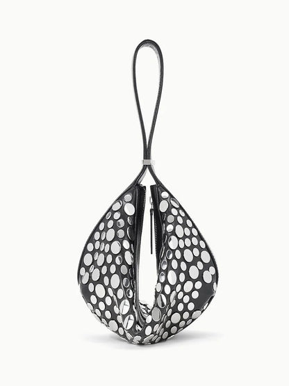 The STAUD Demy Shoulder Bag in Rivets features a black and white teardrop shape, large polka dots, a single top loop handle, and is crafted from soft nappa leather.
